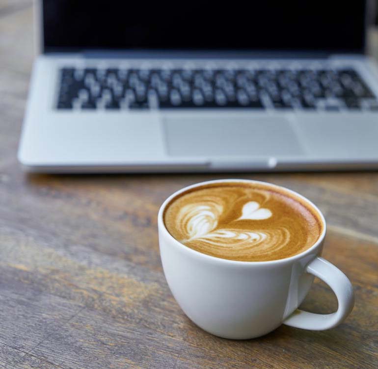Coffee next to a laptop